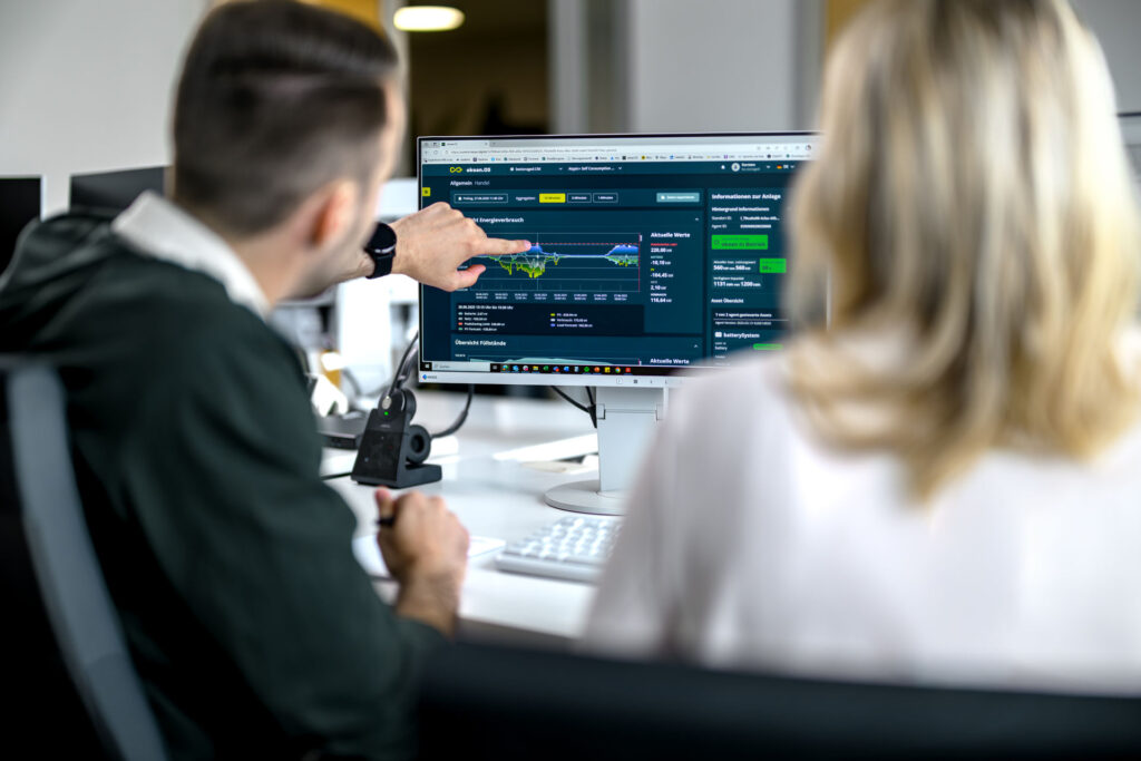Zwei Mitarbeiter schauen auf einen Bildschirm mit einem Energiemanagementsystem